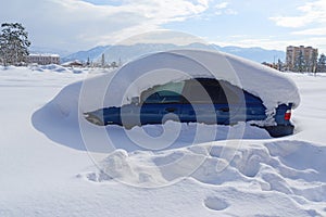 Car is buried under thick layer of snow