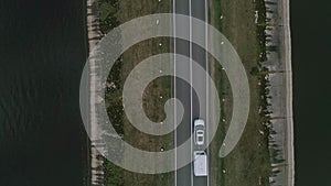 A car with a camper rides on a road across a river in Canada. Family Road Trip