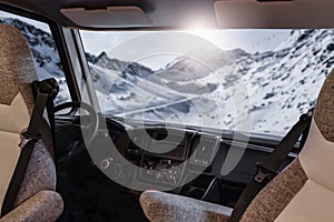 Car Camper travelling in the mountains. Snowy winter mountain background.