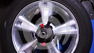 Car at car garage or repair shop rotating wheels for checking a car wheel. Footage. Auto tire fix and repair suspension