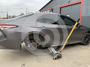 Car in a car service, repair of wheels. Concept: tire fitting, vulcanization, tire change. Car on a jack, changing wheels. Kiev