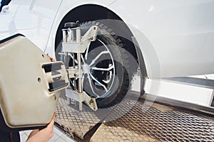 A Car on the Car Steering Wheel Balancer and Calibrate with laser reflector attach on each tire to center driving adjust