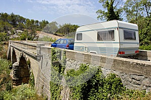 Car with caravan at bridge