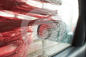 Car Care Business. Automatic Car Wash Process. Spray foam bubble shampoo on the car surface and Tire.