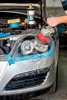 Car Care with Car headlight cleaning with power buffer machine photo