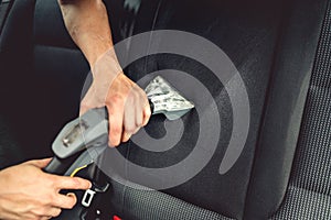 Car care concept, professional steam vacuuming the upholstery of back seats