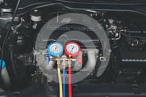 Car care maintenance and service, Close-up measuring manifold gauge on car engine for check refrigerant and filling air