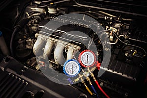 Car care maintenance and service, Close-up measuring manifold gauge on car engine for check refrigerant and filling air