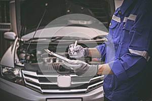 Car care maintenance and servicing, Close-up hand technician auto mechanic checking inspection list after repairing change spare