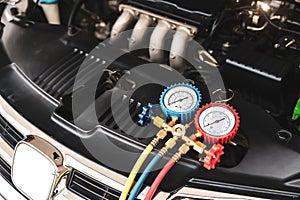 Car care maintenance and servicing, Close-up measuring manifold gauge on car engine for check refrigerant and filling air