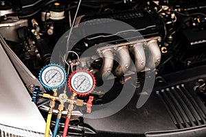 Car care maintenance and servicing, Close-up measuring manifold gauge on car engine for check refrigerant and filling air