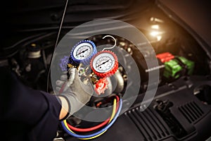 Car care maintenance and servicing, Hand technician auto mechanic using measuring manifold gauge check refrigerant and filling car