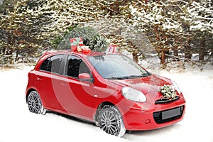 Car with Christmas tree, wreath and gifts in snowy forest