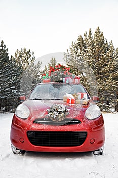 Car with Christmas tree, wreath and gifts in snowy forest