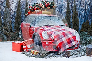 Car with a Christmas tree, wreath and gifts in a snowy forest on a winter day. Christmas decor. Holiday concept.