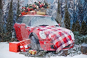 Car with a Christmas tree, wreath and gifts in a snowy forest on a winter day. Christmas decor. Holiday concept.