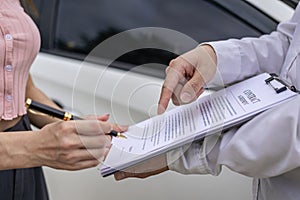 Car claim process Insurance agent after car accident writes on clipboard while inspecting
