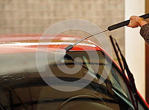 Car cleaning with pressurized water hose photo