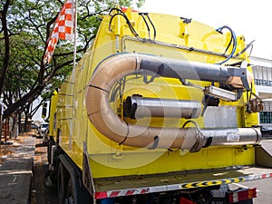 Car for cleaning roads with round brushes on a city street