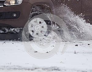 Car close-up skids on a snowy winter road