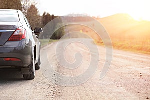 Car on a country road sunset background