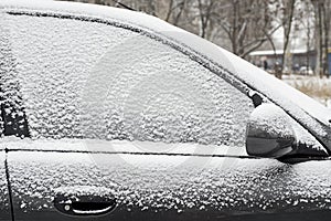 Car covered with fresh white snow on a winter day. Vehicle covered with snow