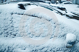 Car covered snow, frozen car side window in winter