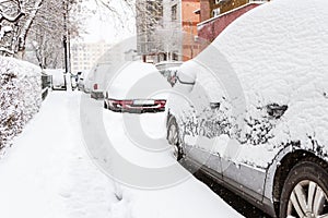 Car covered with snow in the parking after a storm