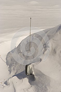 Car covered with snow in winter blizzard snowdrift