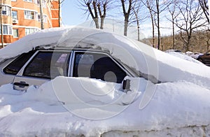 The car is covered in snow. Winter in Russia