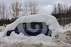 The car is covered in snow. Winter in Russia