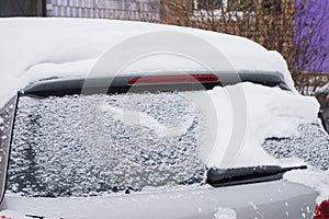 The car, covered with thick layer of snow. Negative consequence of heavy snowfalls. Close-up