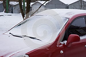 The car, covered with thick layer of snow. Negative consequence of heavy snowfalls. Close-up