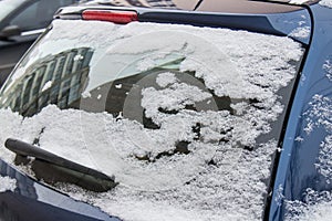 The car, covered with thick layer of snow. Negative consequence of heavy snowfalls. Close-up