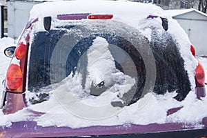 The car, covered with thick layer of snow. Negative consequence of heavy snowfalls. Close-up