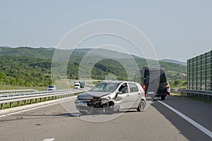 Car crash accident on road, damaged car after collision is deployed against traffic. Front of car damaged by accident