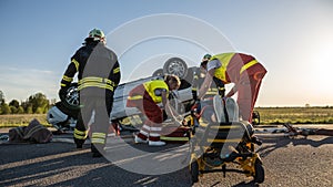 On the Car Crash Traffic Accident Scene: Paramedics Saving Life of a Female Victim who is Lying on