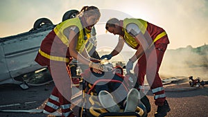 On the Car Crash Traffic Accident Scene: Paramedics Saving Life of a Female Victim who is Lying on