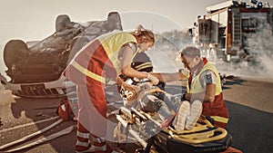 On the Car Crash Traffic Accident Scene: Paramedics Saving Life of a Little Girl Lying on Stretche