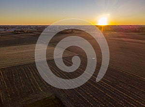 A car crossing a country road, off-road aerial view of a car traveling a dirt road through the fields. Sunset