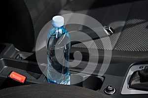 In the car in the cup holder there is a bottle of water, for the driver