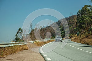 Car on curve road through hilly landscape