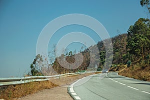 Car on curve road through hilly landscape