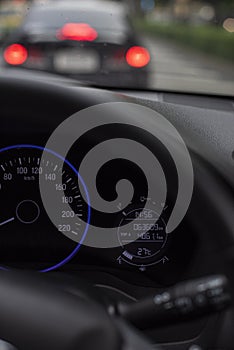 Car dashboard or console panel with Illuminated digital miles screen including gauges telling fuel, battery and lighting system.