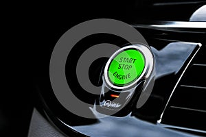 Car dashboard with focus on green engine start stop button. Modern car interior details. start/stop button. Car inside. Ignition r