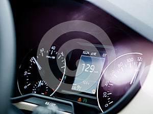 Car dashboard with speedometer showing 129 kilometres per hour
