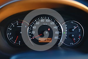 Car dashboard with speedometer and tachometer in black color.