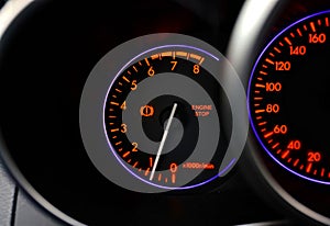 Car dashboard with stop engine sign. Car malfunction, engine maintenance is required. Closeup illuminated car dashboard with