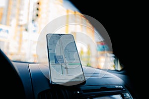 In car dashboard view with smartphone showing Yandex maps to show the way thru
