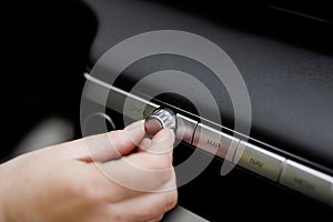 Car dashboard volume knob. Driver& x27;s hand adjusts volume control of car radio. Female hand control radio or music in